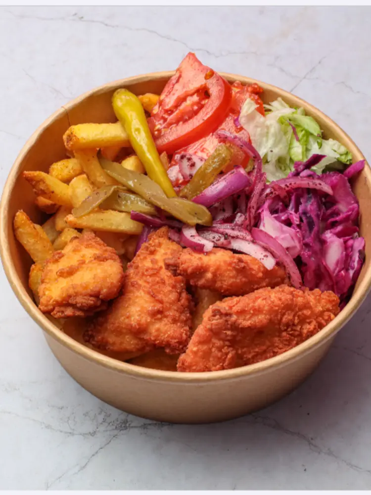 Kraft bowl of fried chicken pieces with fries, salad, pickles and red cabbage