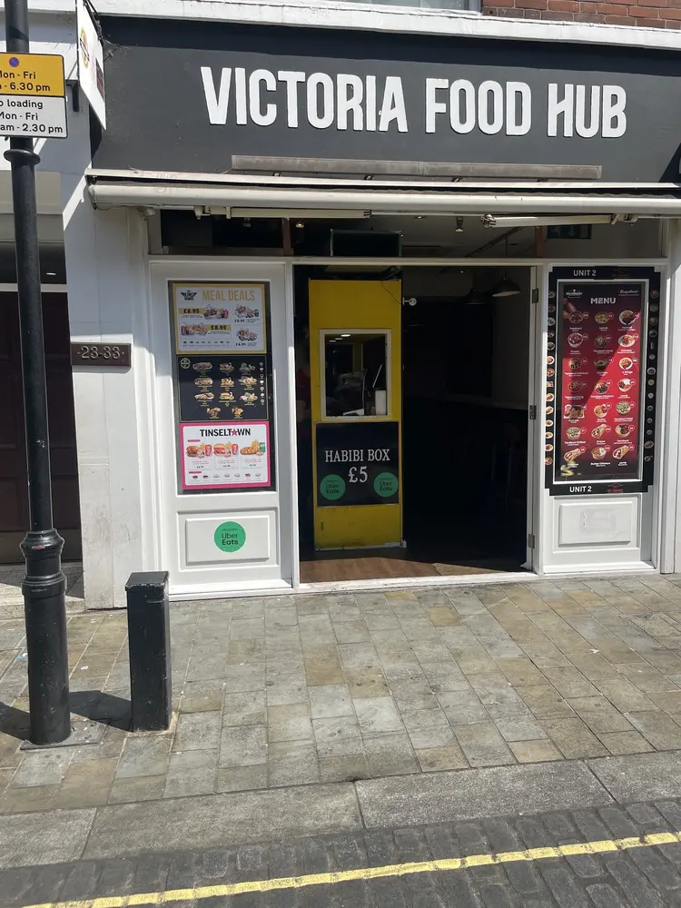 Black Victoria Food Hub shopfront with menu boards either side of the open entrance